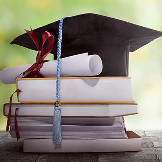 Graduation cap sitting on top of a pile of books